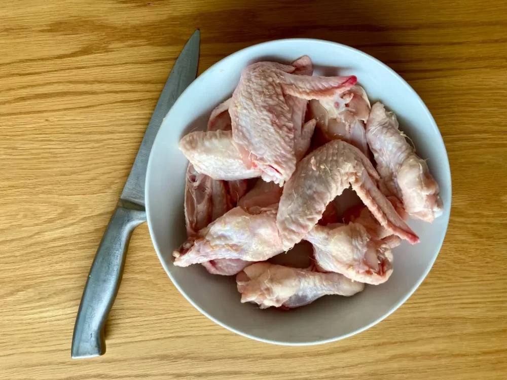 Chicken wings being split into drumettes and wingettes